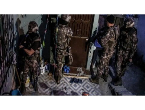 Uyuşturucu operasyonuna dair bir görselde, ön planda uyuşturucu paketleri, iki bardak sıvı ve “Polis” yazılı sarı güvenlik şeridi yer alıyor. Arka planda polis yeleği giymiş bir görevli görülüyor. Üzerinde "Ankara'da Uyuşturucu Operasyonu: 200'den Fazla Kişi Gözaltında" yazısı büyük harflerle dikkat çekiyor.